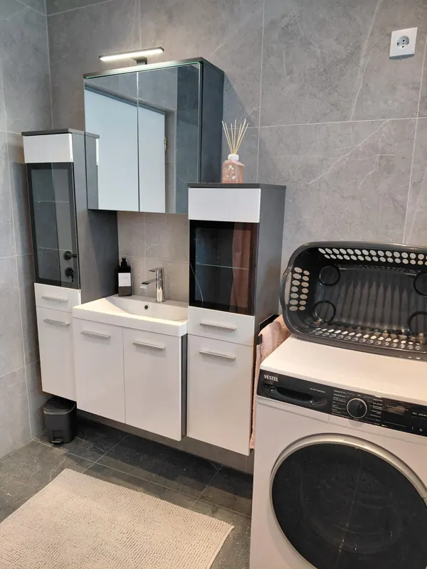 Bathroom with vanity unit, mirror cabinet and washing machine