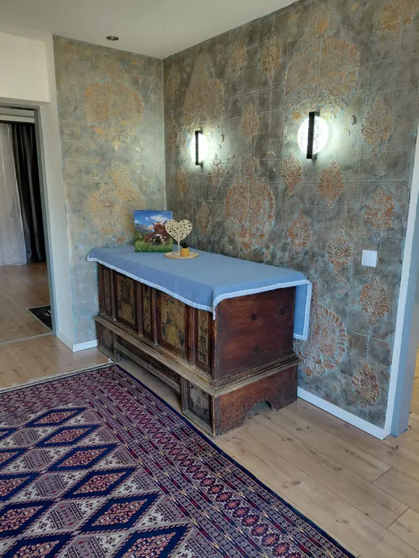 Hallway with a painted wooden chest and an oriental rug