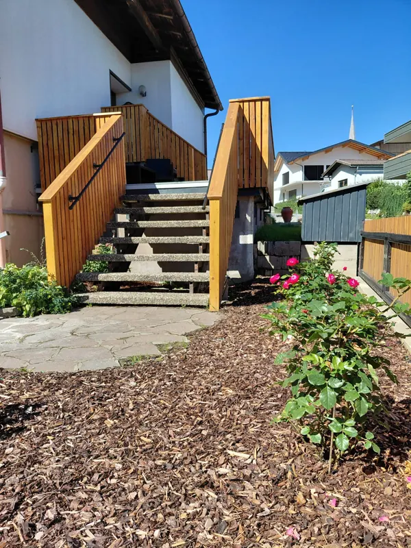 Wooden stairs to the entrance with a rose bush