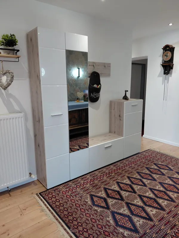 White wardrobe unit with mirror and rug