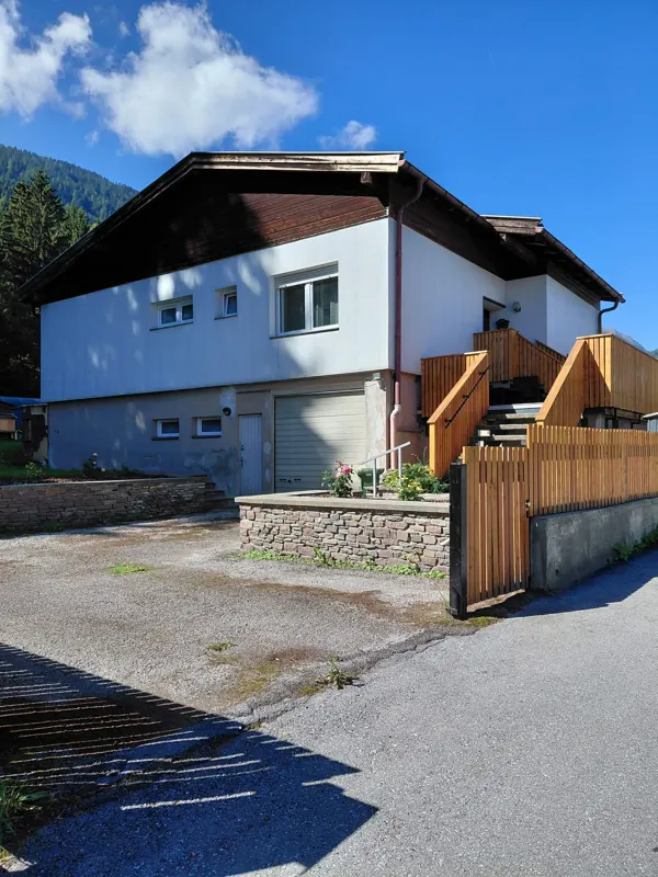 Outside view of the house with driveway and wooden stairs