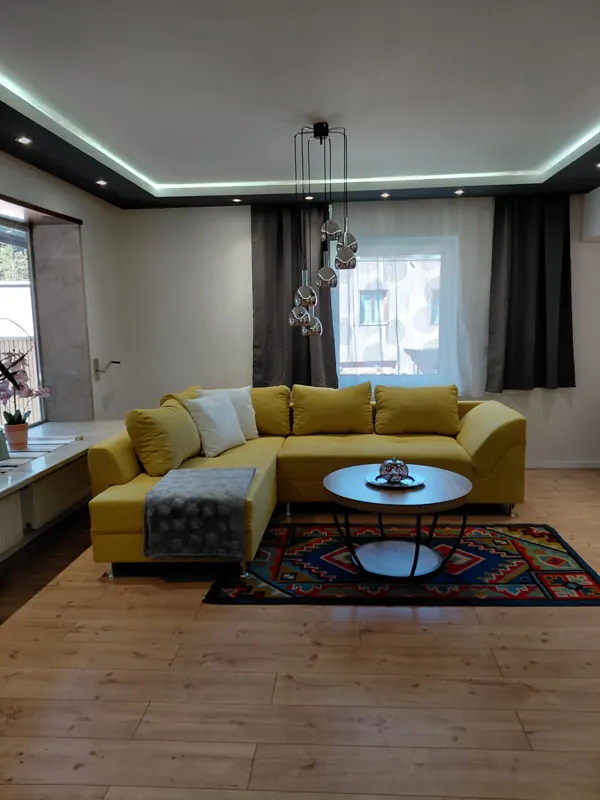 Yellow corner sofa with a round coffee table in the living room
